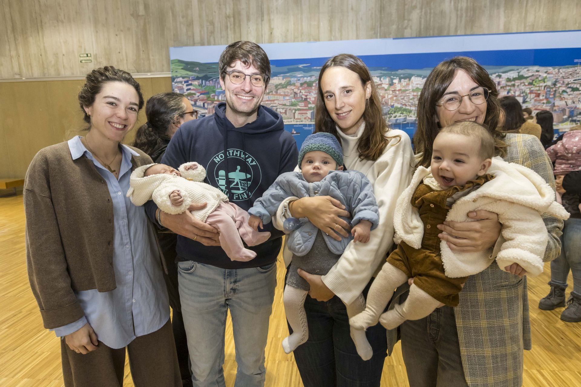 Un grupo de padres con sus bebés en brazo.