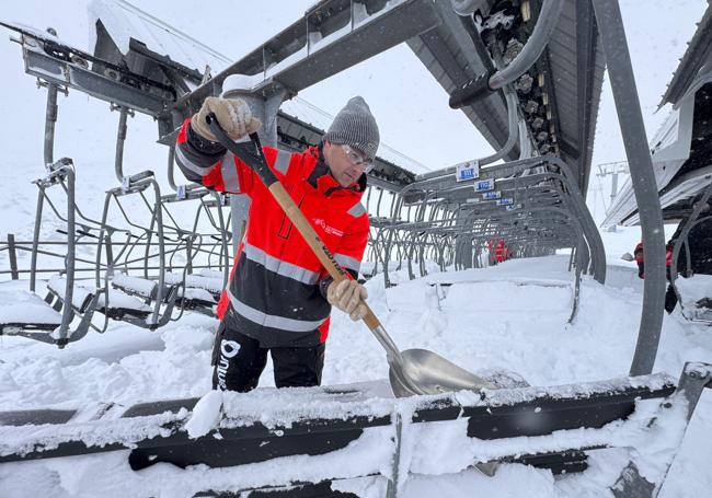 En los remontes, un trabajador aparta con su pala la nieve de cada telesilla.