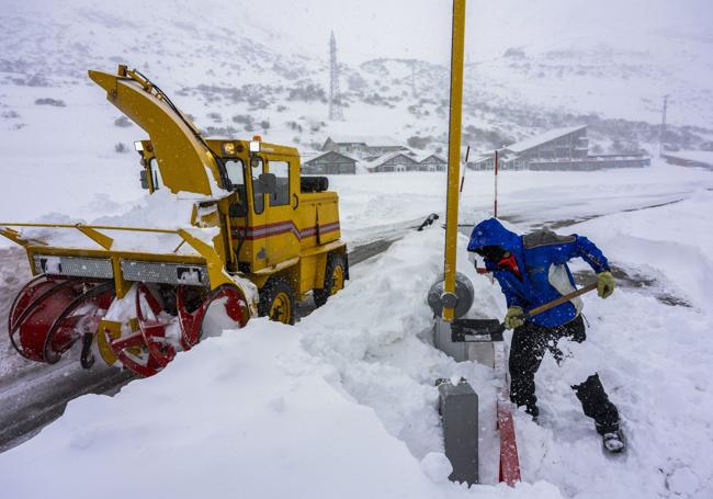 En la entrada de acceso a la estación, un operario quita nieve de la carretera para poder hacer un camino y que circulen los vehículos.