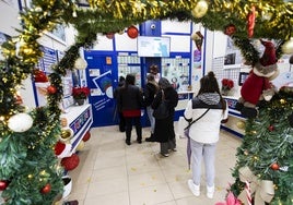 Varias personas hacen cola en La Anjana, en Calvo Sotelo, a la espera de llevarse sus décimos de Navidad.