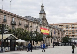 Vecinos caminan frente al Palacio municipal de Torrelavega, cerrado desde hace años, en el Bulevar Demetrio Herrero.