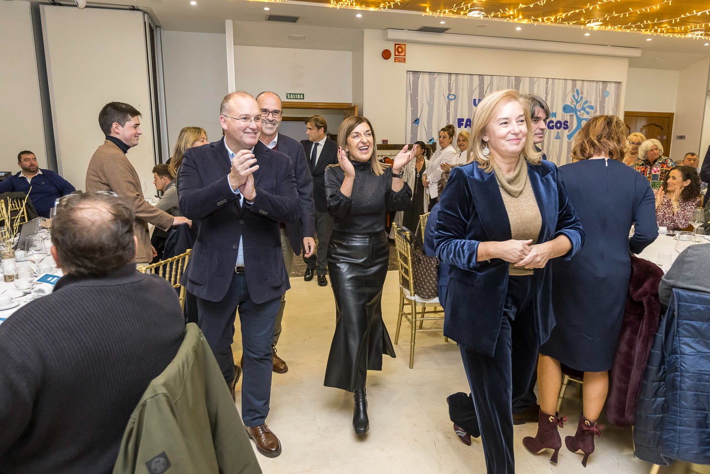 María José González encabeza la entrada al salón junto a María José Sáenz de Buruaga y Miguel Tellado. 