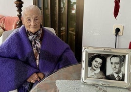 Martina posa en su casa en Colindres con una foto de su juventud.