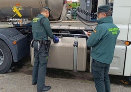 Dos agentes de la Guardiai Civil revisan uno de los despósitos de gasoil de un camión.