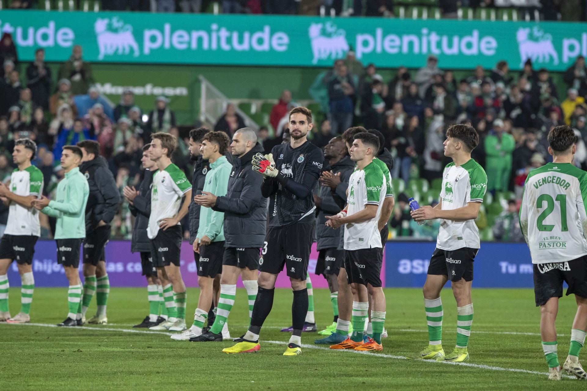 Los jugadores del Racing, con caras largas, saludan a La Gradona. 