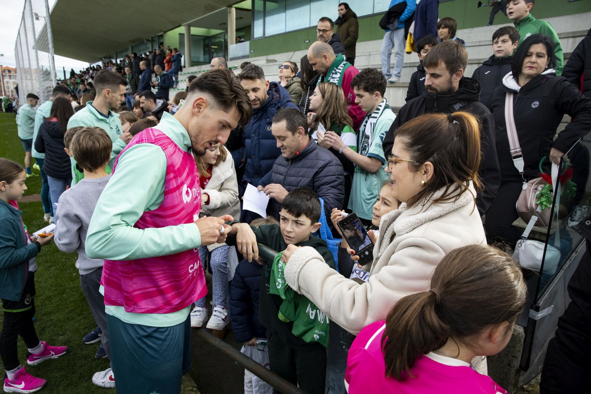 Vencedor firma autógrafos en una sesión de entrenamiento abierta al público.