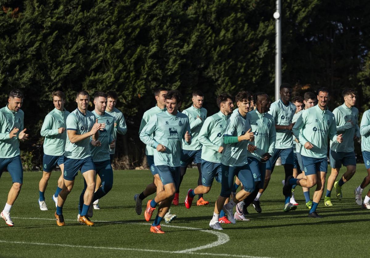 Los jugadores del Racing corren al inicio del entrenamiento de ayer en La Albericia.