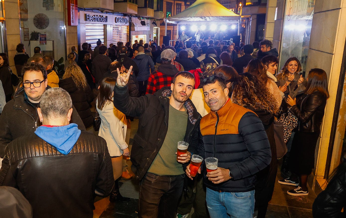 Dos amigos posan con la multitud detrás.