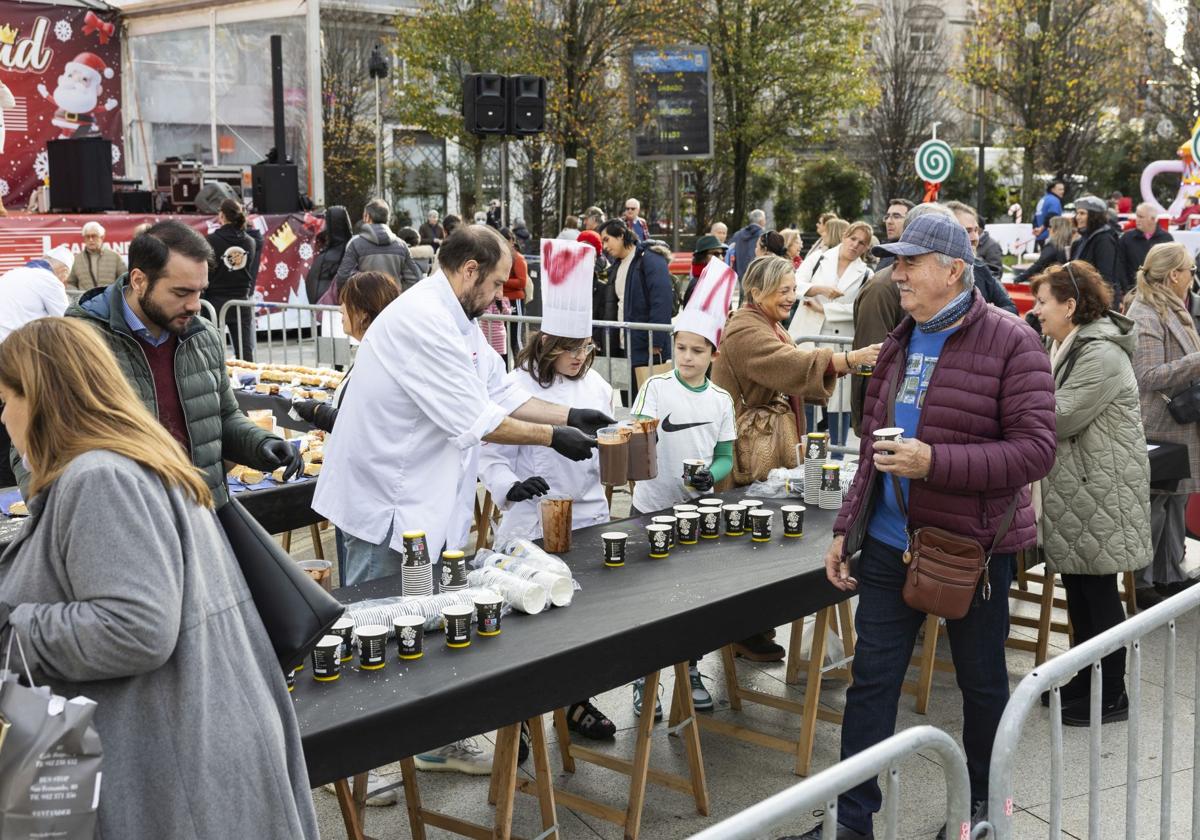 Concejales y voluntarios reparten chocolate y roscón entre los vecinos que se acercaron al Ayuntamiento.