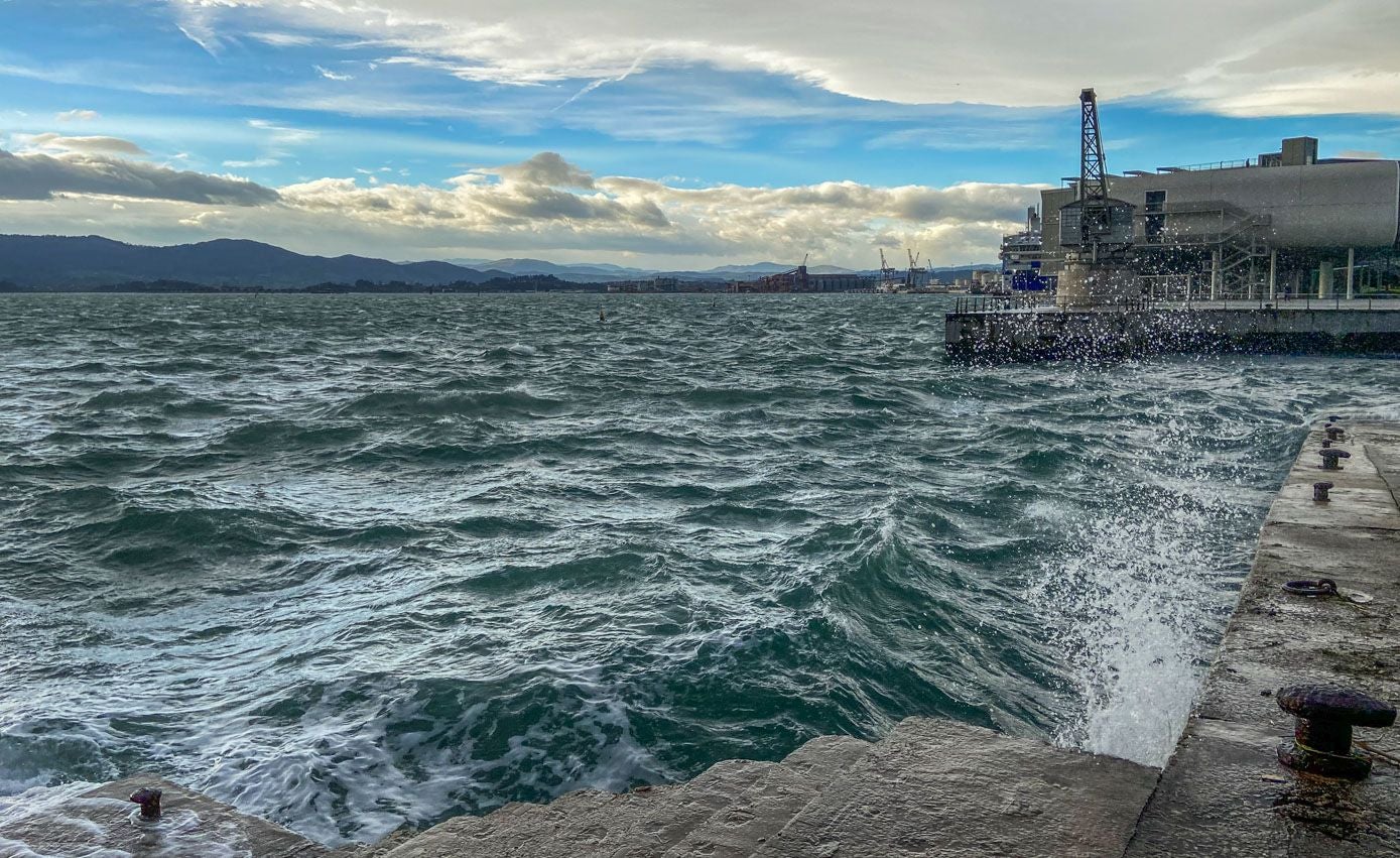 La surada en la bahía, con la Grúa de Piedra al fondo