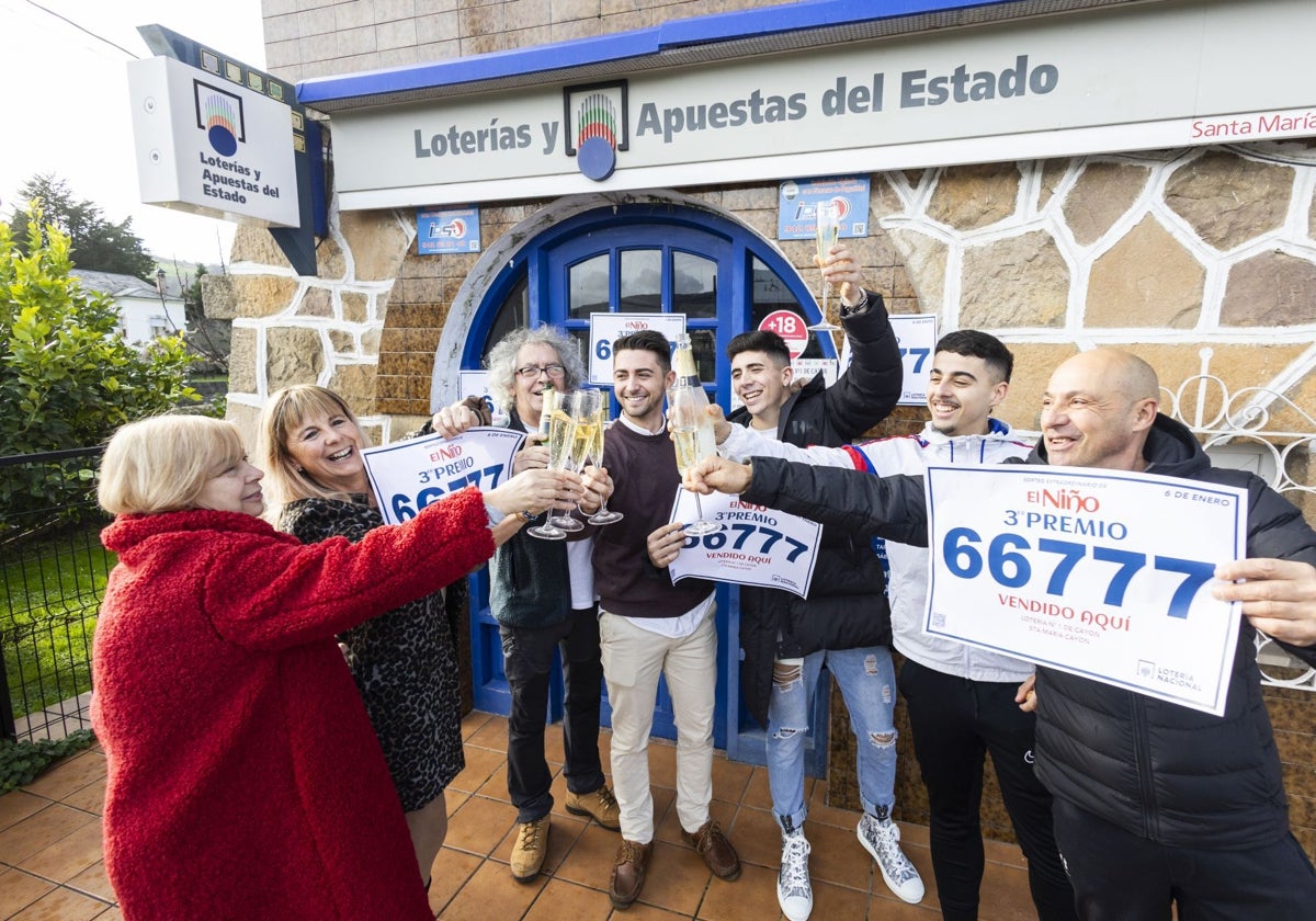 Juan Carral, en el centro de la imagen, celebra con amigos y familiares el tercer premio vendido en Santa María de Cayón.