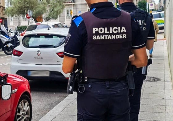 Imagen de archivo de policías de Santander observando varios vehículos estacionados con destrozos.