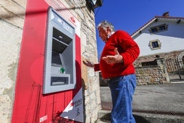 Rafael Canal, vecino de Bárcena de Pie de Concha, saca dinero en uno de los cajeros rurales.