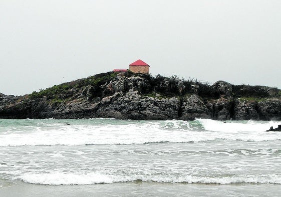 La ermita de San Pedruco, erigida en un islote homónimo, se divisa rehabilitada desde la playa de Ris.