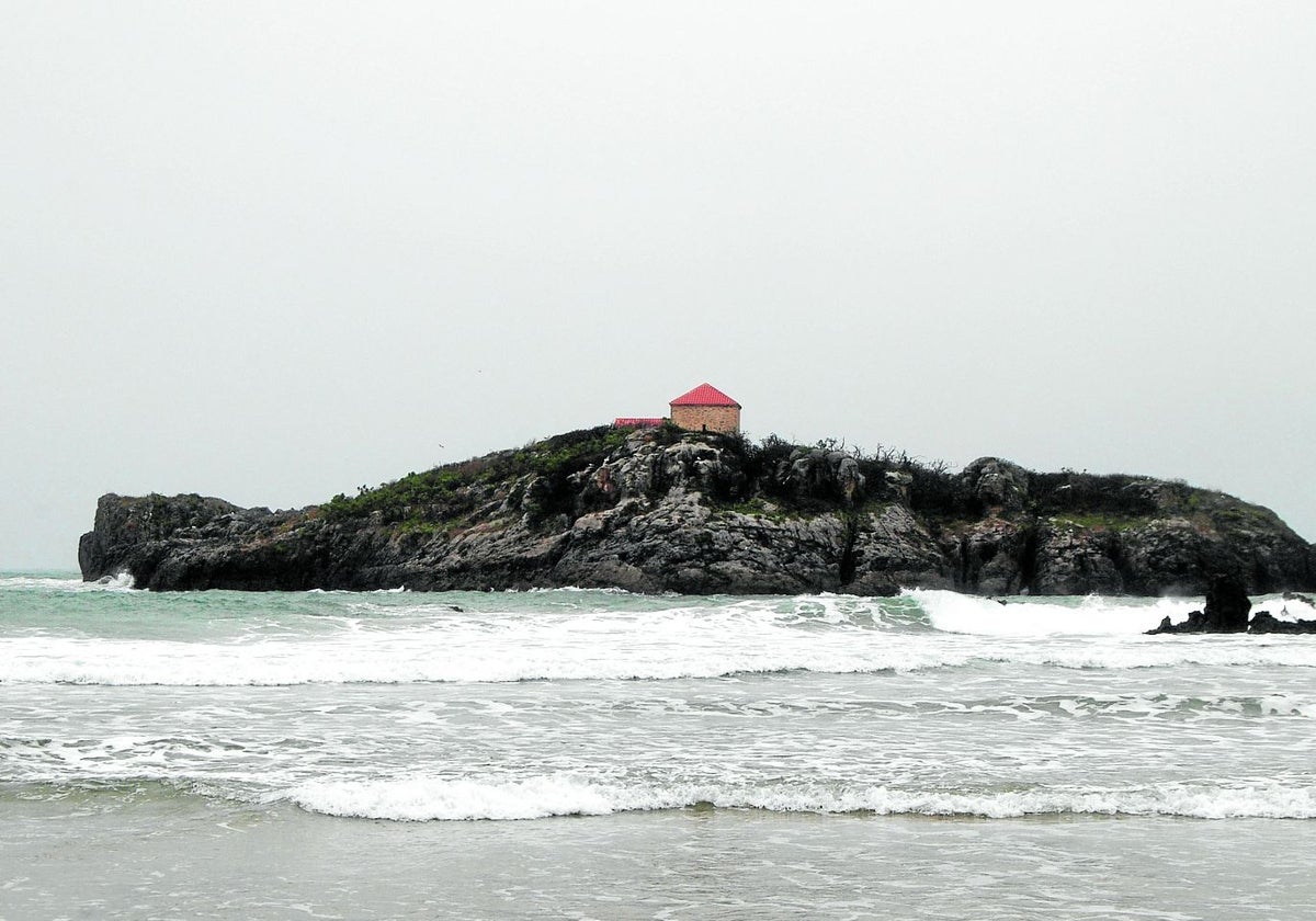 La ermita de San Pedruco, erigida en un islote homónimo, se divisa rehabilitada desde la playa de Ris.