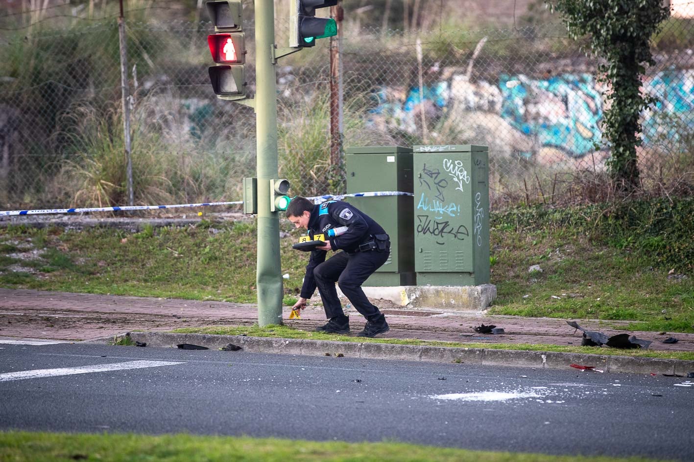 Un agente de la Policía Local recoge pruebas y repasa la trayectoria del vehículo en la zona tras el accidente. 