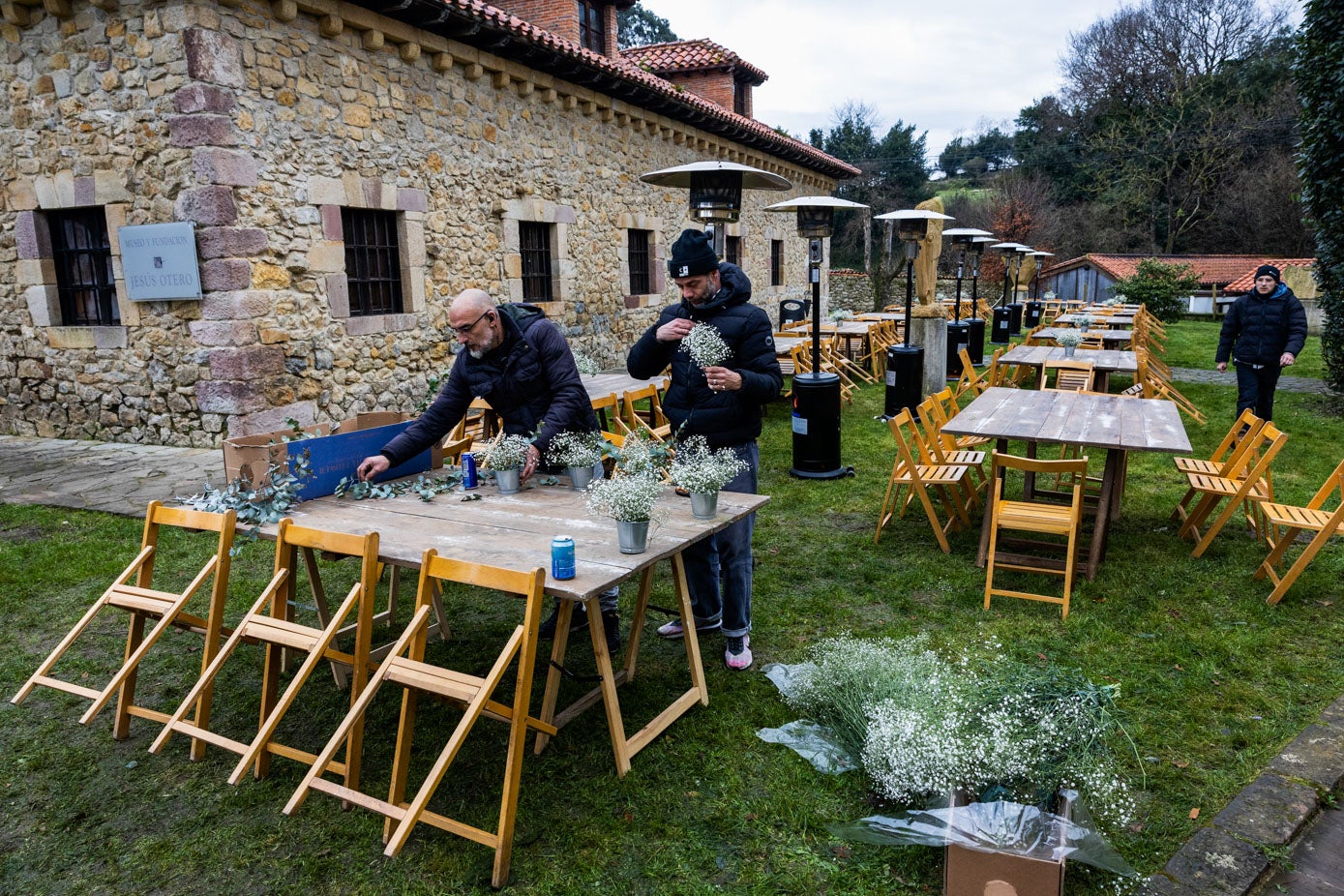 Dos miembros de producción decoran las mesas de los comensales.