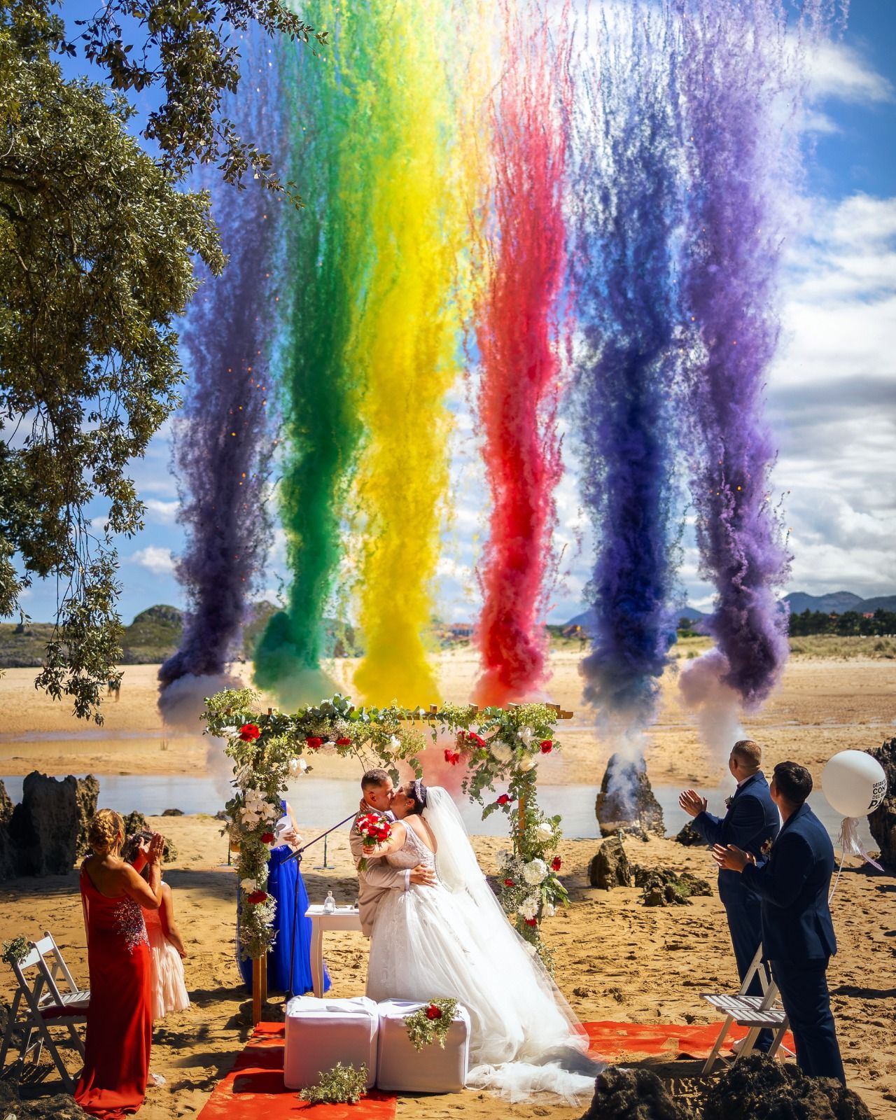 Marián Revilla y David Fernández se casaron en el Hotel Olimpo de Isla el 7 de septiembre y quisieron que su día estuviera lleno de color, por lo que eligieron humo de varios tonos. Los novios recuerdan que, tras diez días sin parar de llover, la mañana de su boda salió el sol, como se aprecia en esta imagen. 