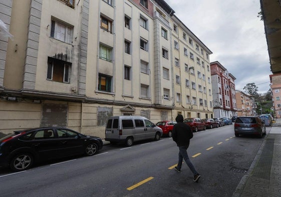 Un vecino cruza la calle junto al número 9 de la calle Marqueses de Valdecilla y Pelayo, ayer, en La Inmobiliaria (Torrelavega).