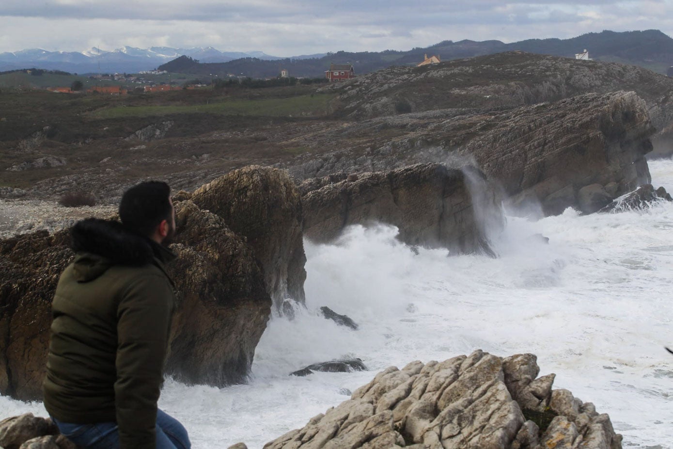 Un hombre contempla el mar enbravecido.