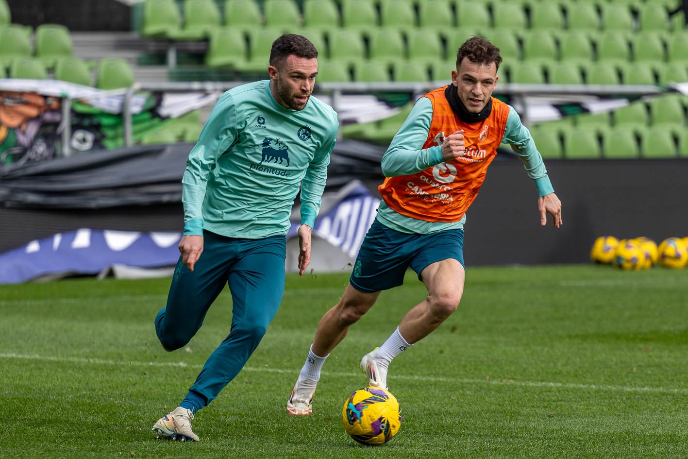 Manu Hernando avanza con el balón, perseguido por Íñigo Vicente. 