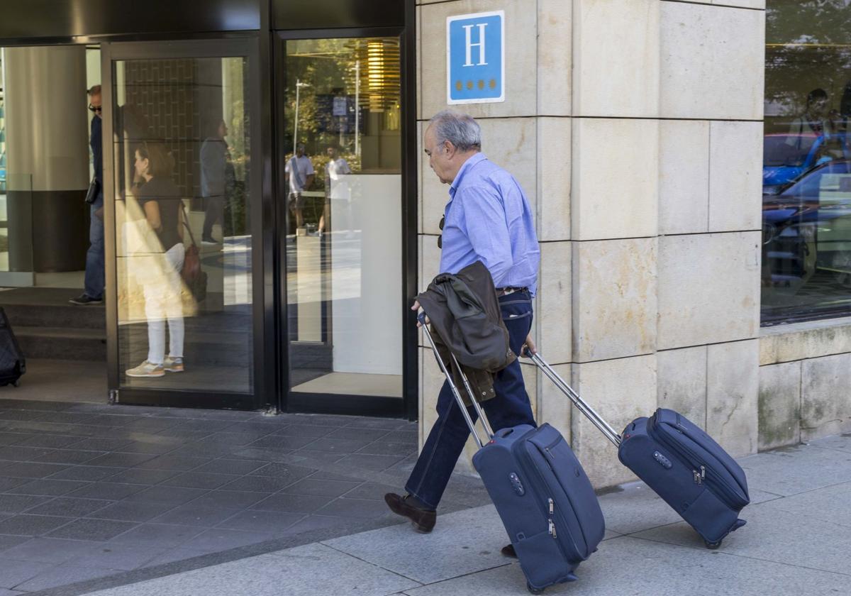 Un turista accede con sus dos maletas al hotel Bahía, en el centro de Santander.