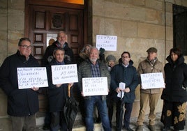 Una representación de los afectados acudió ayer al Ayuntamiento con carteles pidiendo soluciones.