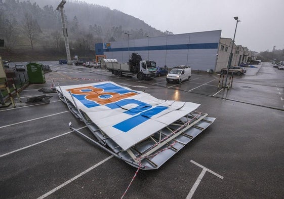 Cartel desprendido por el viento en el supermercado Lupa de Pesués.