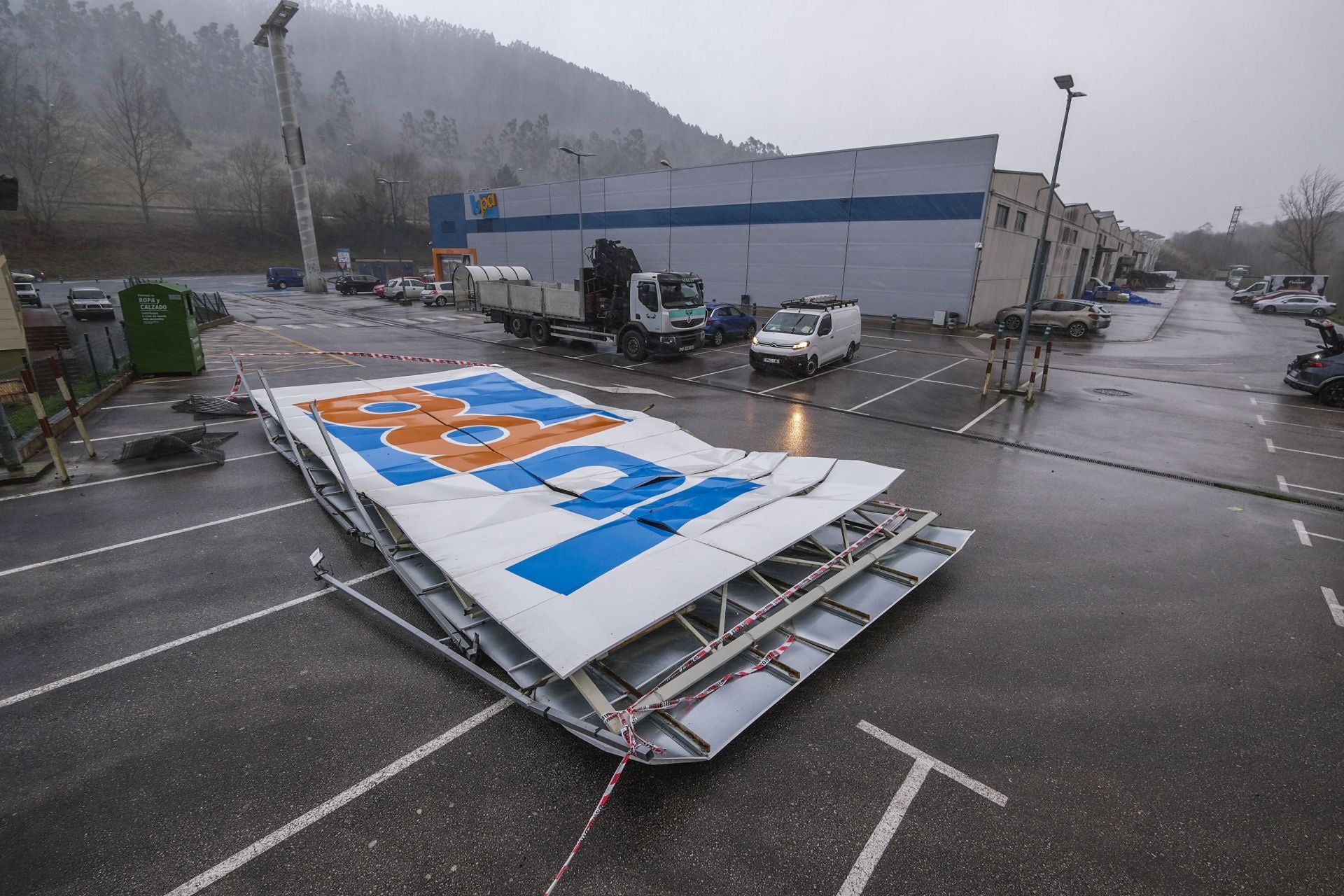 El viento ha roto y desprendido el cartel del supermercado Lupa en Pesués.