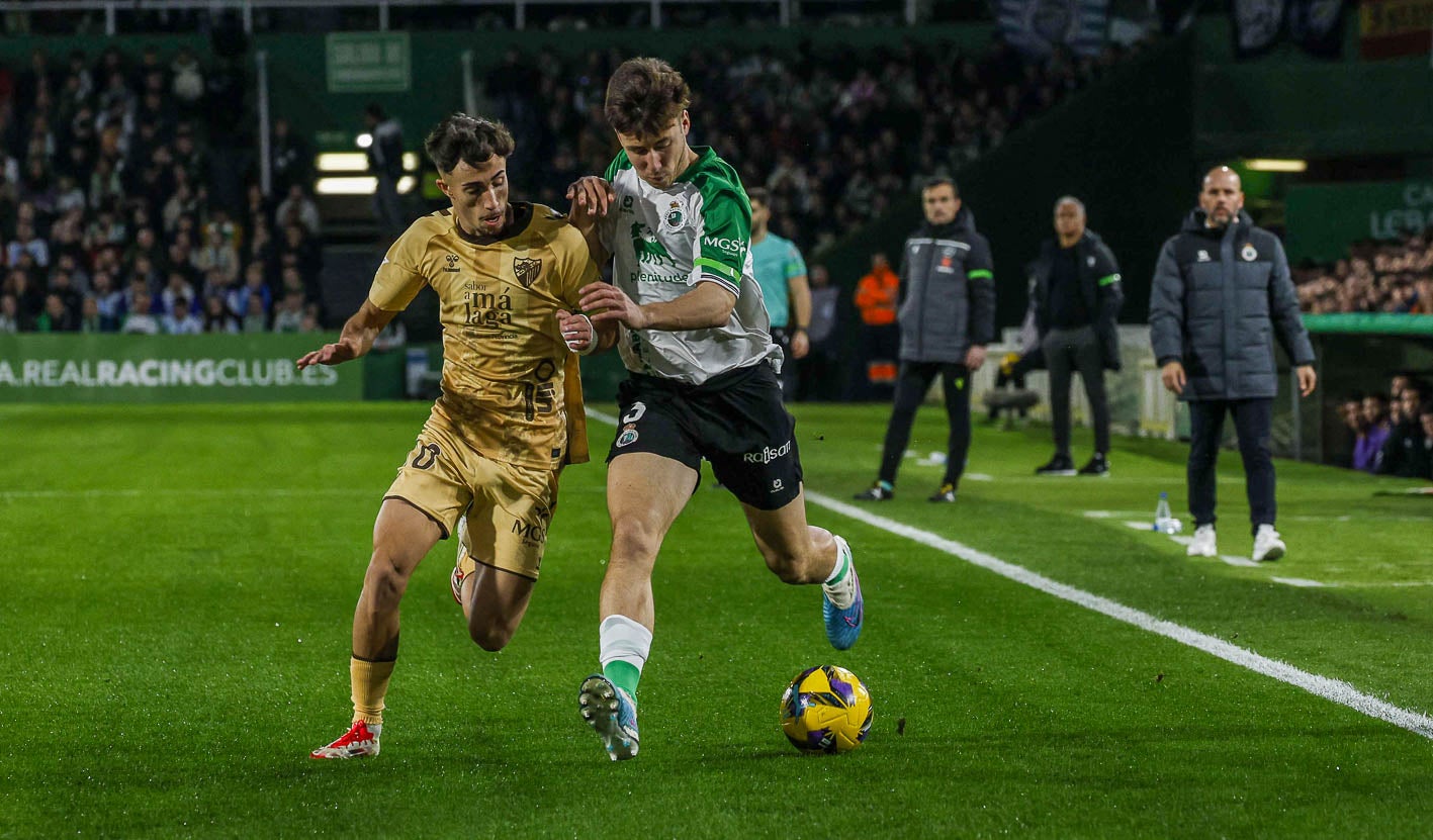 Saúl, del Racing. avanza con la pelota mientras Larrubia, del Málaga, trata de robársela.