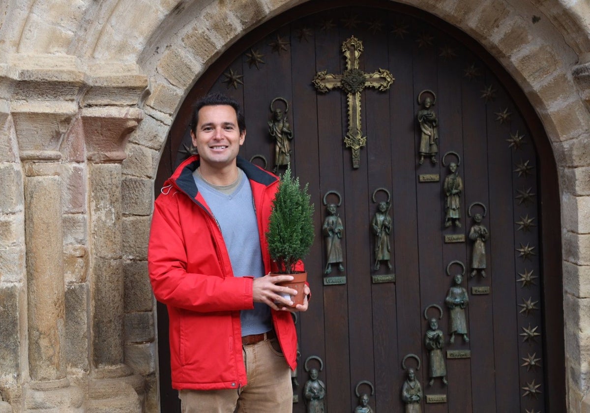 Adrián Pelayo porta el ciprés que llevará al Vaticano en la puerta del Perdón.