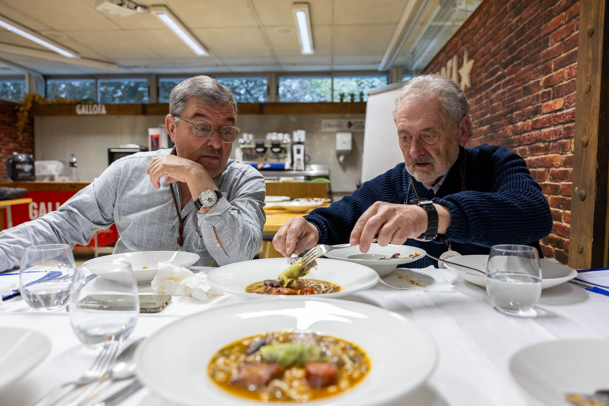 Manuel Rodríguez y Juan José García, jurado y cofrades, comentan uno de los platos.