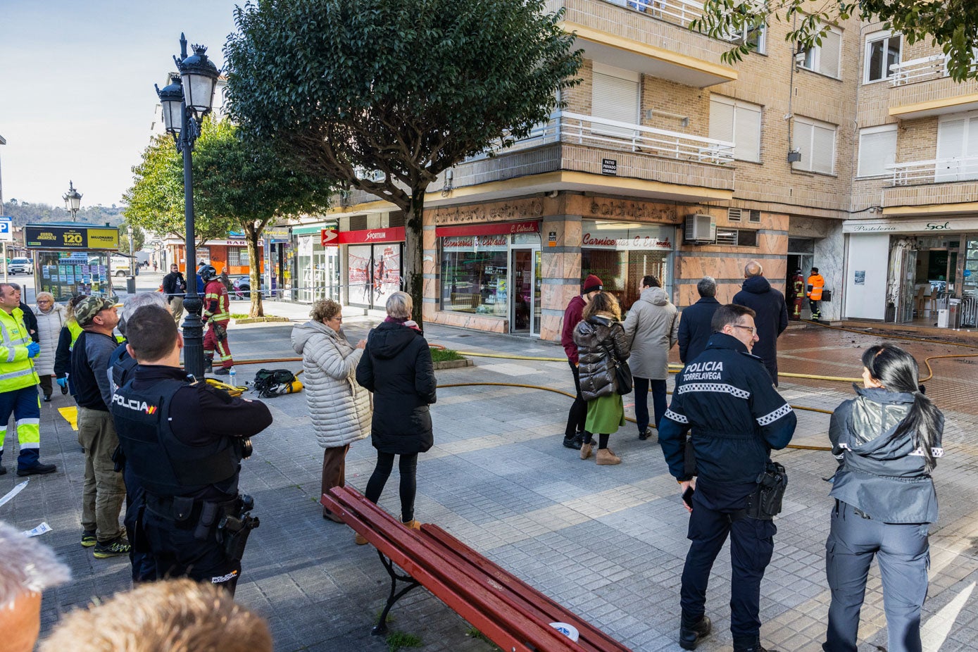 Policías, personal sanitario, autoridades y vecinos de la zona, atentos a la evolución del incendio, este jueves, en la Avenida del Besaya. 