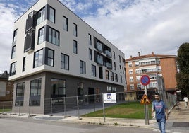 Vecinos caminan frente al nuevo centro de acogida, en la calle Pablo Garnica de Torrelavega.