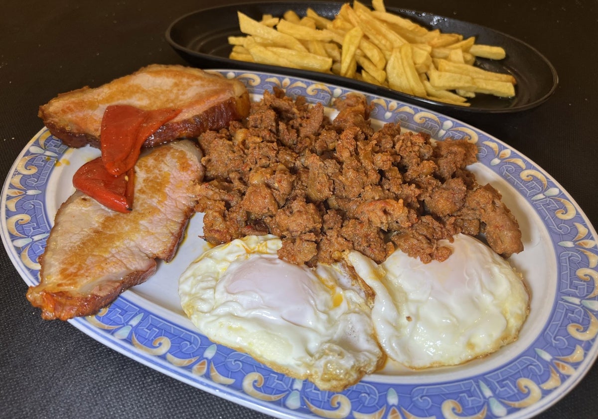 Huevos con lomo de cerdo, gijas, pimientos y patatas fritas.