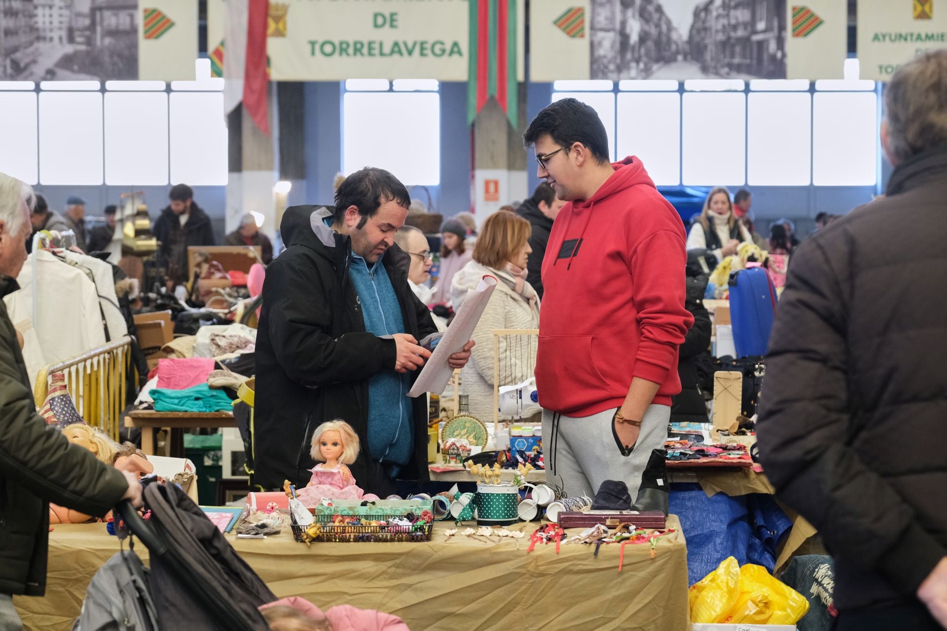 Dos hombres ojean una publicación antigua en uno de los estand de la feria. 