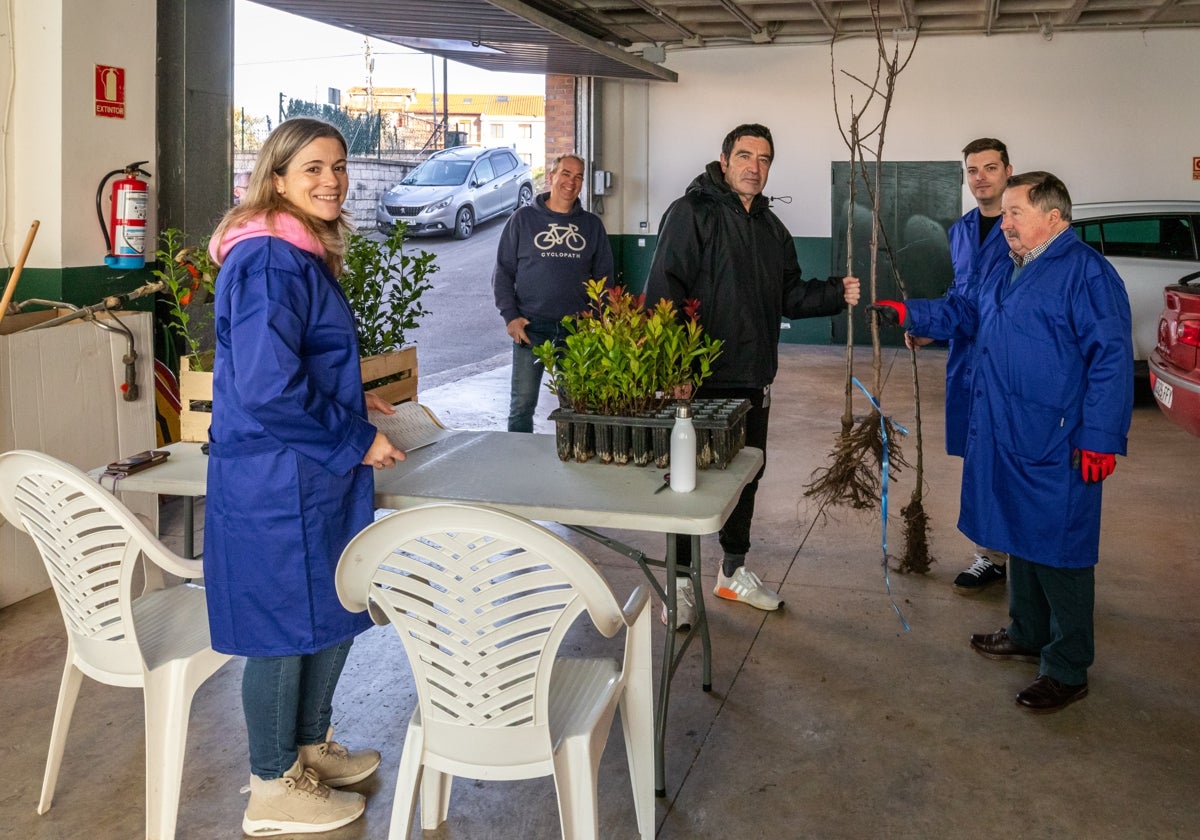 Los concejales María José Álvarez, Fernando Sañudo y David Esteban entregan los árboles a los vecinos.