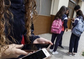 Varios estudiantes manejan sus teléfonos móviles, una escena muy difìcil de ver hoy en los centros educativos de Cantabria.