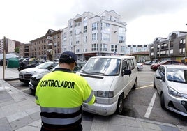 Un controlador anota los datos de un vehículo para poner una sanción, en una plaza de ERA ubicada en la calle Pando, en Torrelavega.