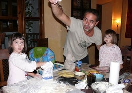 Dos hermanas cocina con su padre.