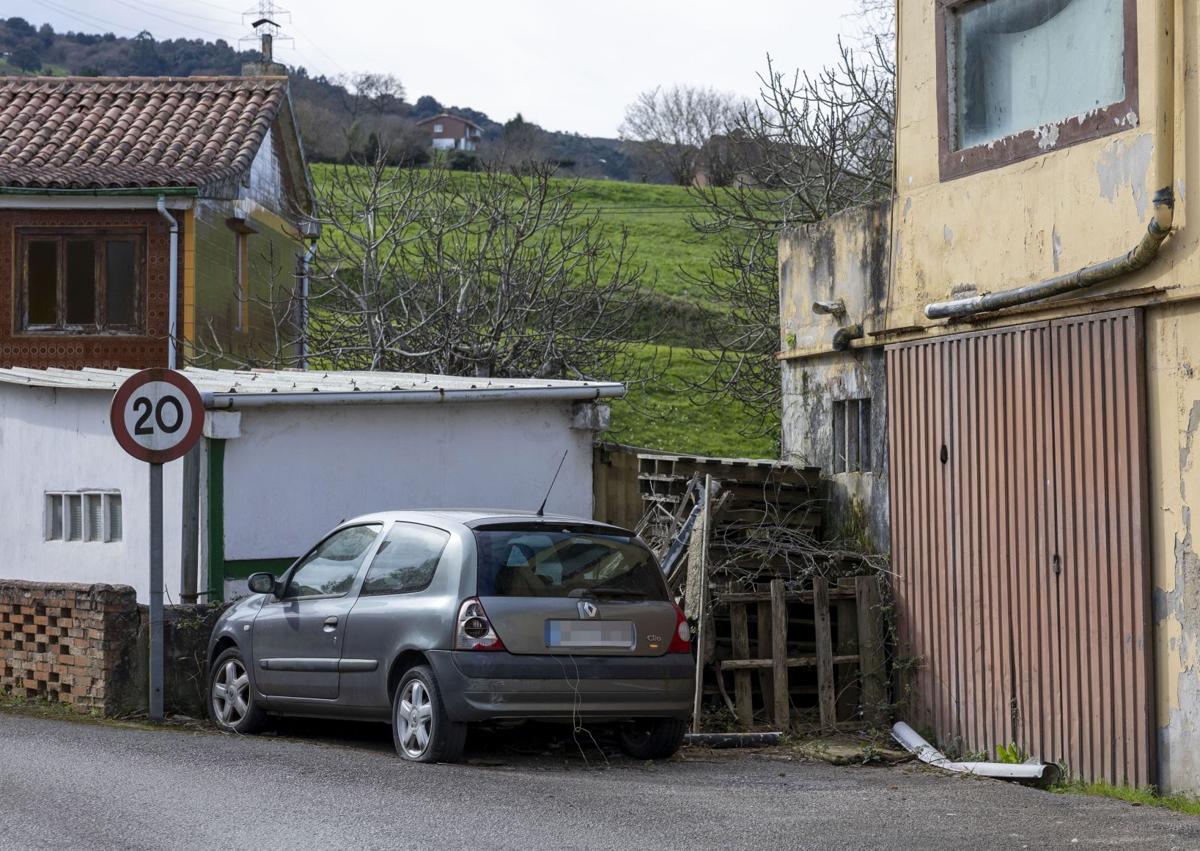 Imagen secundaria 1 - El jardín de la vivienda. El coche de Eva Jaular y la ilustración del gato que preside la puerta de acceso al jardín. 