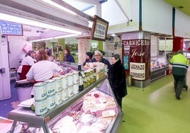 Vecinos compran en uno de los puestos del mercado municipal, ayer, en Torrelavega.