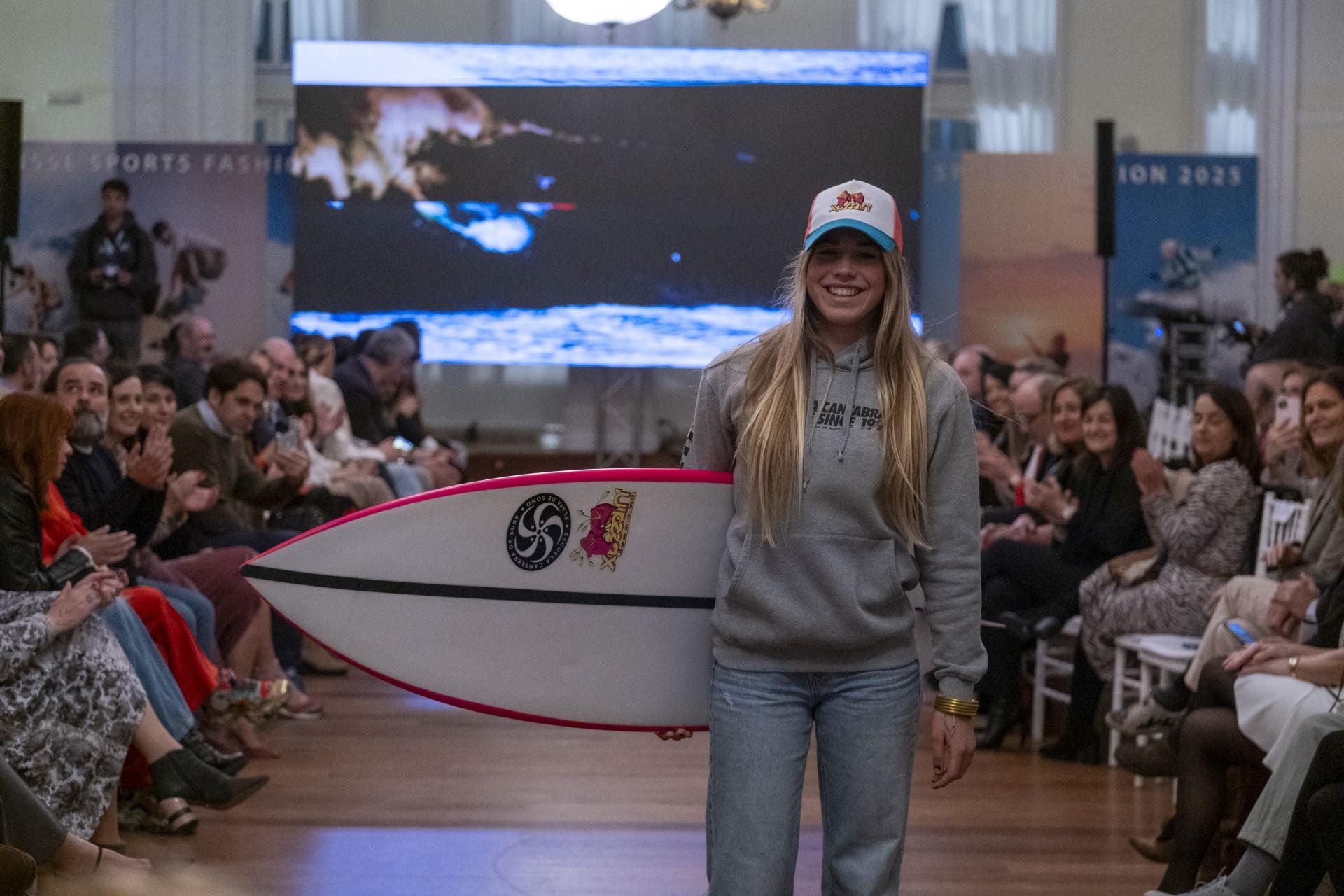 Otra de las participantes en el desfile con tabla, sudadera y gorra.