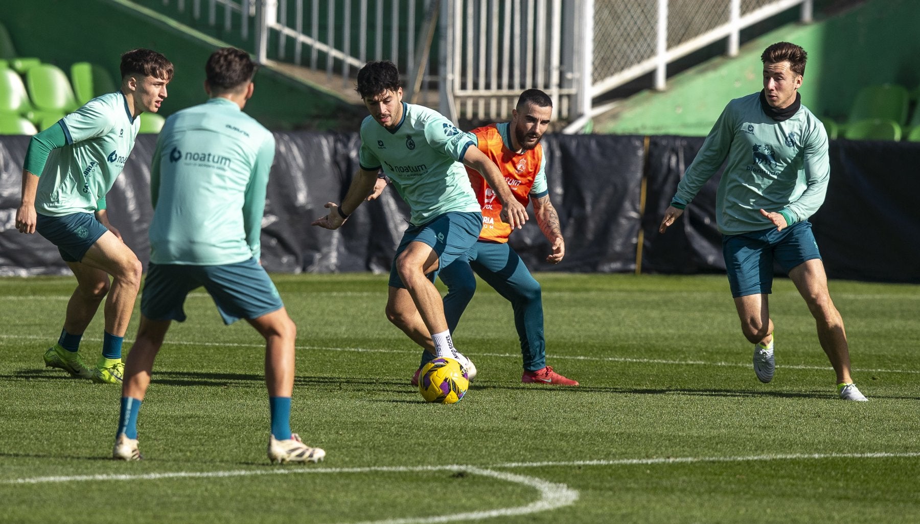 Meseguer conduce el balón, rodeado de compañeros, en una sesión en los Campos de Sport.