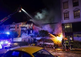 Bomberos durante la madrugada del suceso apagando las llamas que consumían el edificio.