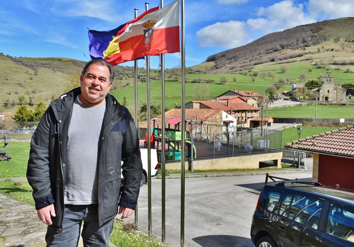 Eduardo Gutiérrez, en la entrada al Ayuntamiento, con el pueblo del San Miguel de Aguayo al fondo.