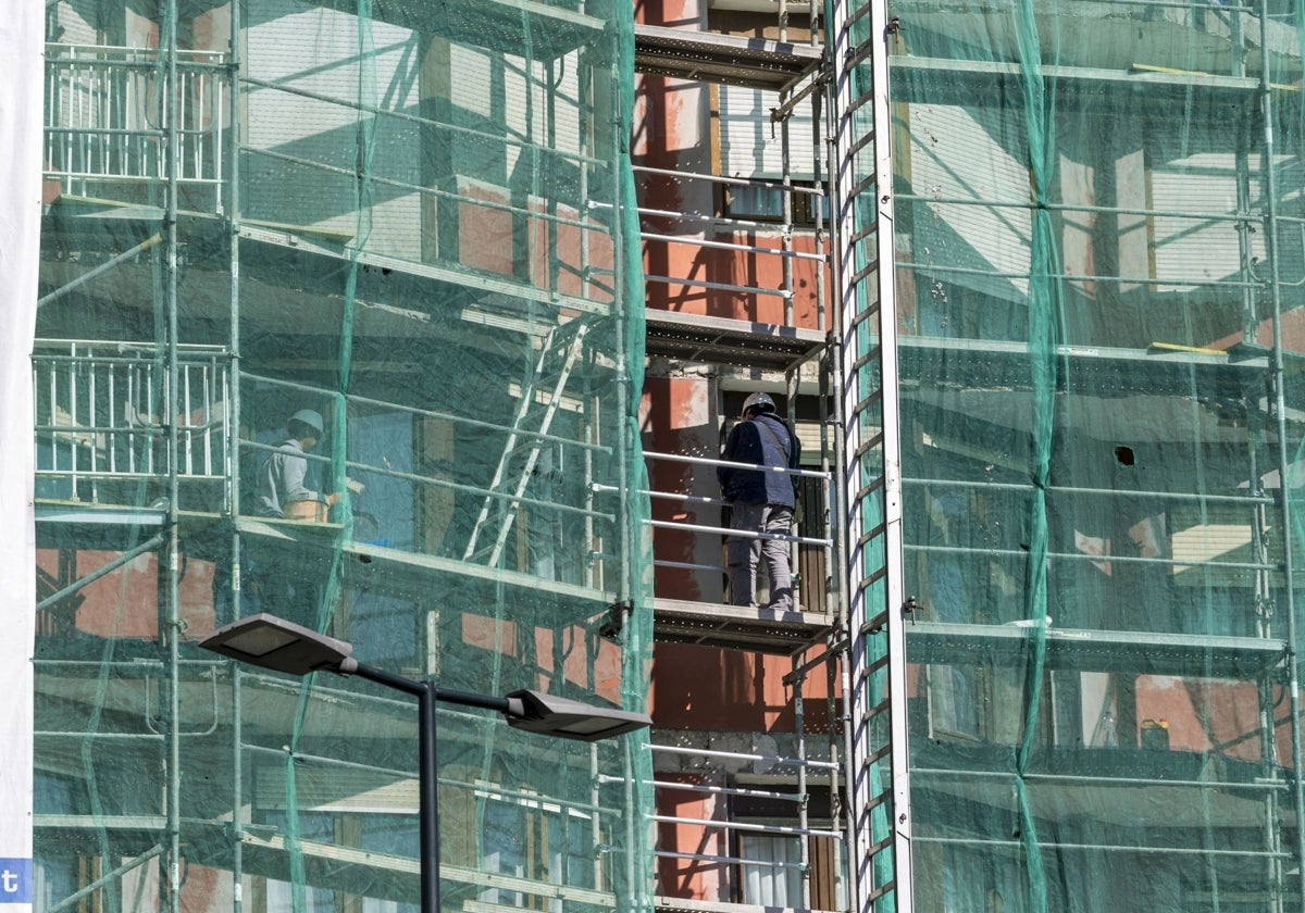 Un grupo de obreros realiza labores de restauración de una fachada, ayer, en un edificio de Santander.