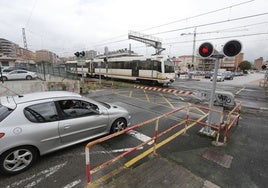 Un tren abandona Torrelavega en dirección a Santander, desde el paso a nivel de Pablo Garnica.