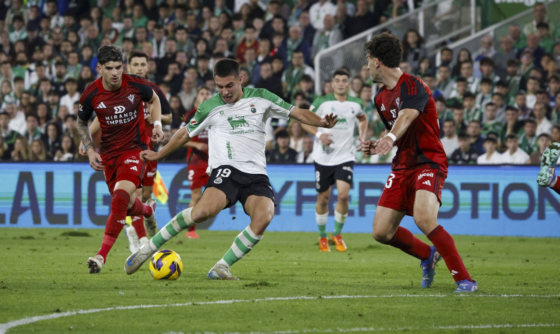 Karrikaburu, del Racing, conduce el balón ante dos rivales del Mirandés en El Sardinero.