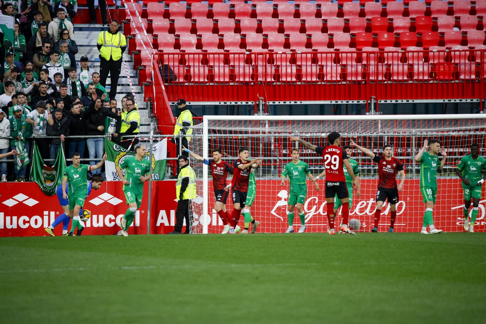 Los jugadores del Racing piden saque de puerta y los del Mirandés córner en una acción del partido. 